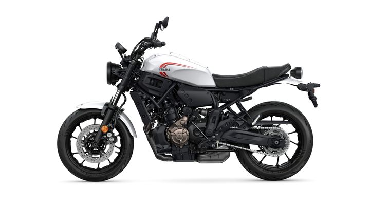 A white and black Yamaha motorcycle is displayed in profile, showcasing its sleek design, round headlight, and modern features, with a visible engine and detailed wheels.
