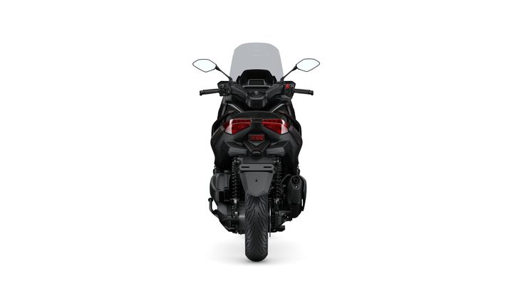 A rear view of a black motorcycle featuring dual red tail lights, mirrors, and a large windscreen.