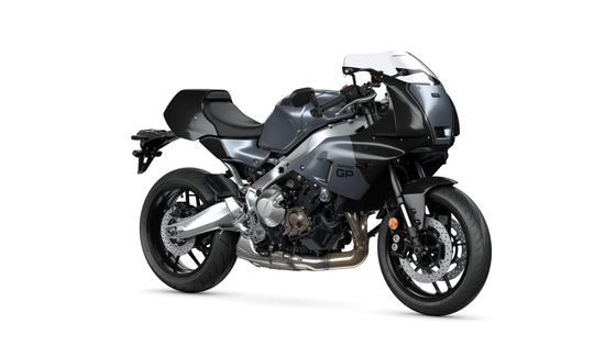 A dark gray motorcycle with a sleek design, featuring a prominent front fairing, a sporty frame, and dual exhaust pipes, positioned on a white background.