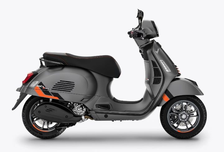 A modern grey motor scooter with black seat and orange detailing, isolated on a white background.