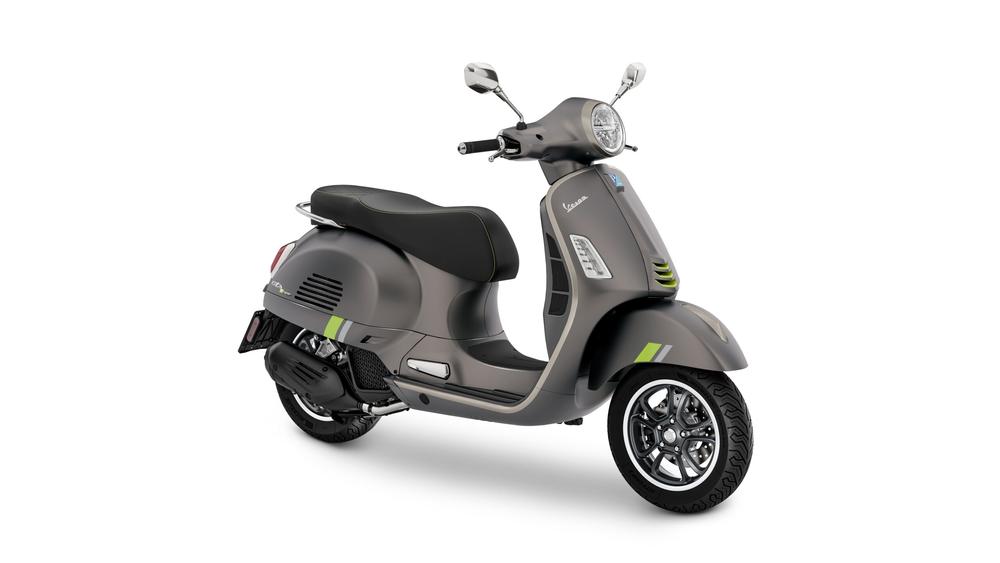 A modern gray scooter with green accents, featuring a black seat and stylish chrome mirrors, positioned on a white background.