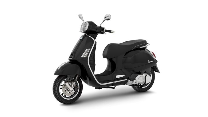 A sleek black Vespa scooter positioned at a slight angle, showcasing its rounded body, chrome accents, and modern design elements.
