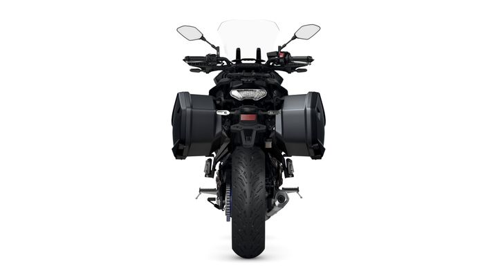 A black motorcycle viewed from the front, featuring large side panniers, a windshield, and a detailed tire design.