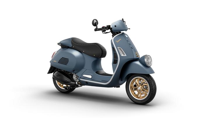 A stylish blue scooter with a black seat, featuring gold accents on the wheels and a modern design.