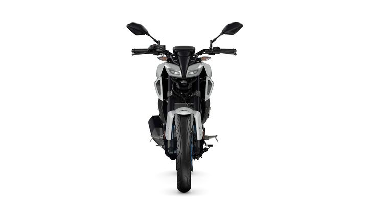 A front view of a modern motorcycle with a sleek design, featuring a white and black color scheme, distinct headlights, and a prominent wheel.