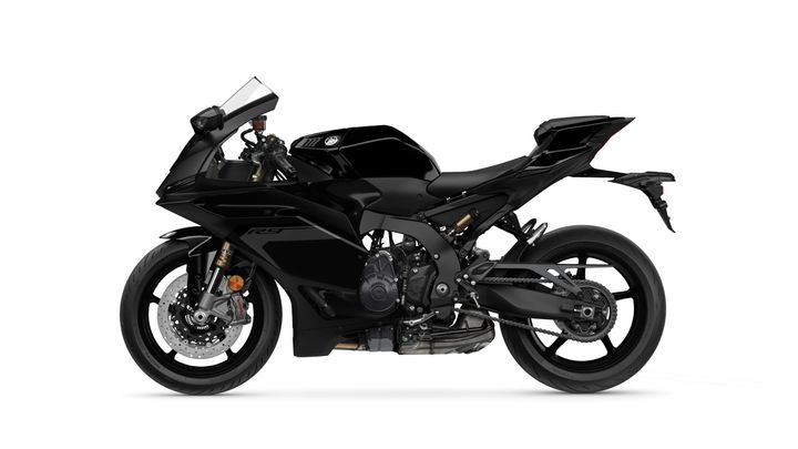 A sleek black sports motorcycle viewed from the side, showcasing its aerodynamic design, sharp lines, and detailed components including the front wheel, suspension, and engine.