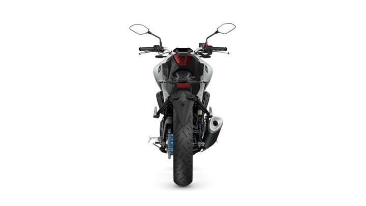 A rear view of a motorcycle showcasing its sleek design, prominent tail light, handlebars, and a large rear tire on a white background.