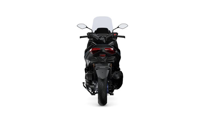 A rear view of a sleek, modern motorcycle with a black finish, featuring a high windshield, dual tail lights, and a prominent rear tire.