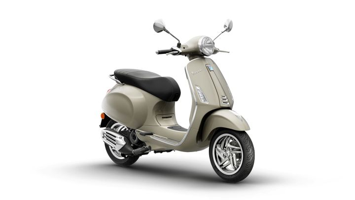 A beige scooter with a sleek design, featuring a black seat, chrome accents, and a rounded headlight, set against a white background.