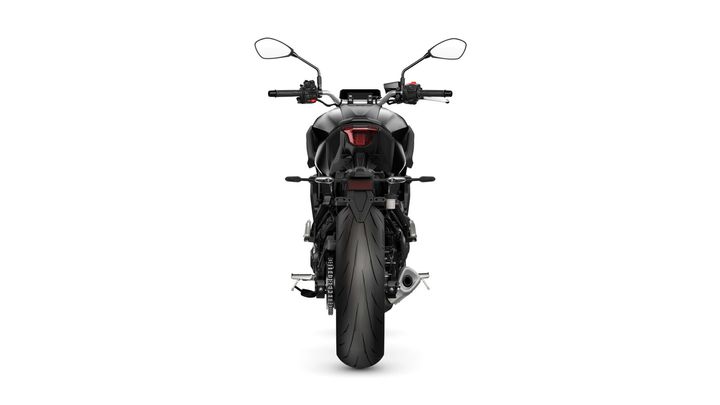 A sleek black motorcycle viewed from the rear, showcasing its wide rear tire, tail light, and handlebars with mirrors.