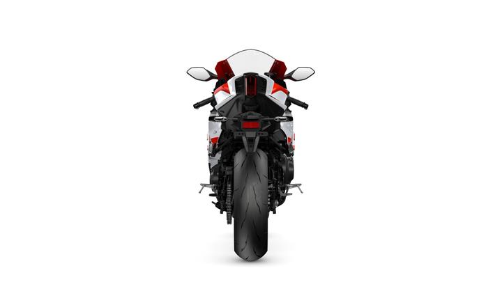 A rear view of a sleek motorcycle with a red and white color scheme, showcasing its dual exhaust pipes, large rear tire, and modern design features against a white background.