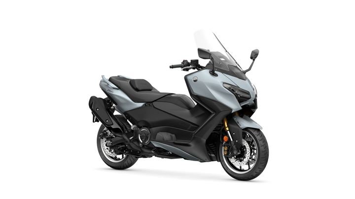 Yamaha 2026 TMAX Tech MAX A side view of a modern gray and black motorcycle with a tall windshield, showcasing sporty design features and a sleek profile.