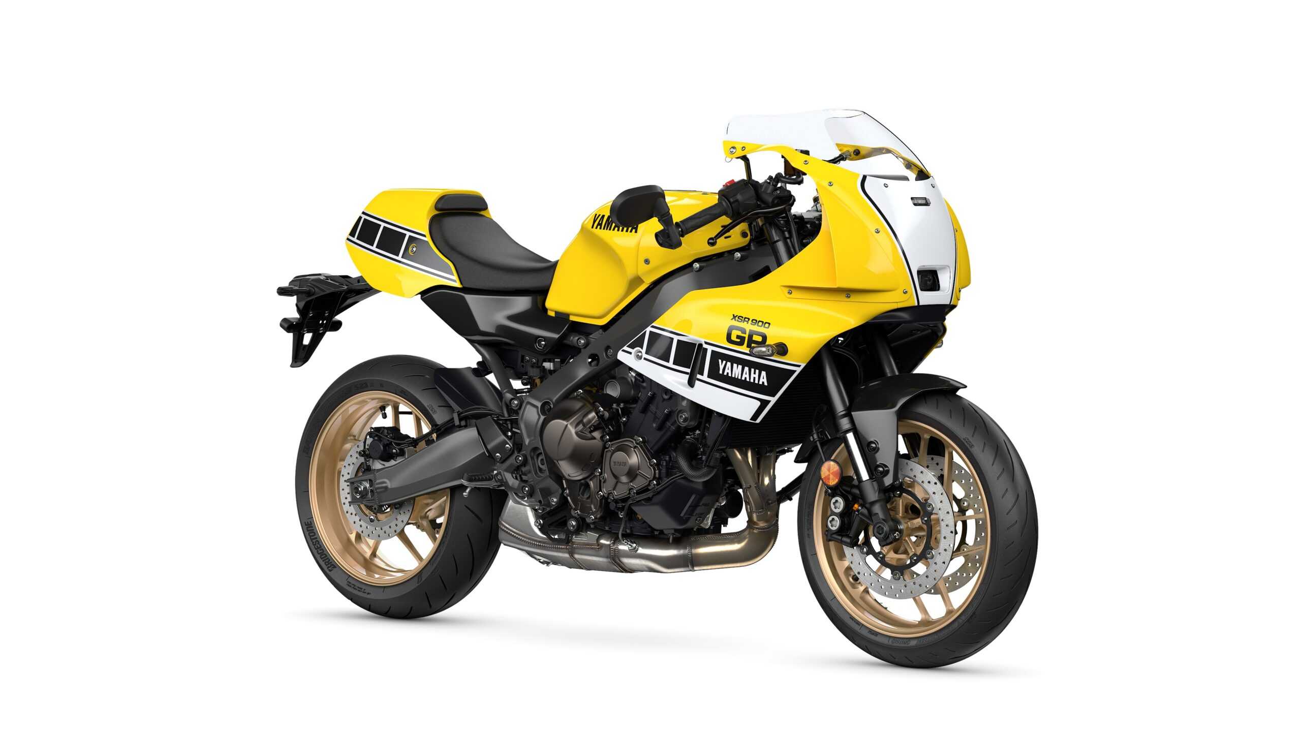 Yamaha 2026 XSR900 GP A yellow Yamaha motorcycle with a sporty design, featuring black and white accents, gold wheels, and a distinctive front fairing.