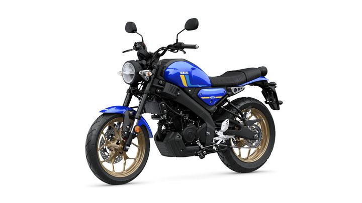 A blue Yamaha motorcycle with gold alloy wheels, featuring a round headlight, black seat, and sleek design, positioned on a white background.