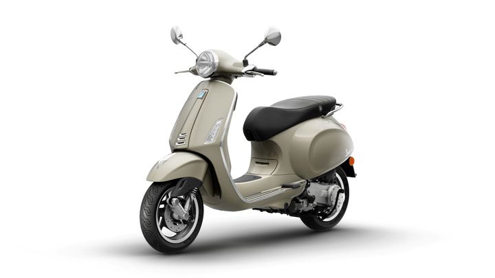 A stylish beige scooter with a black seat, chrome accents, and a vintage design, positioned at a slight angle on a white background.