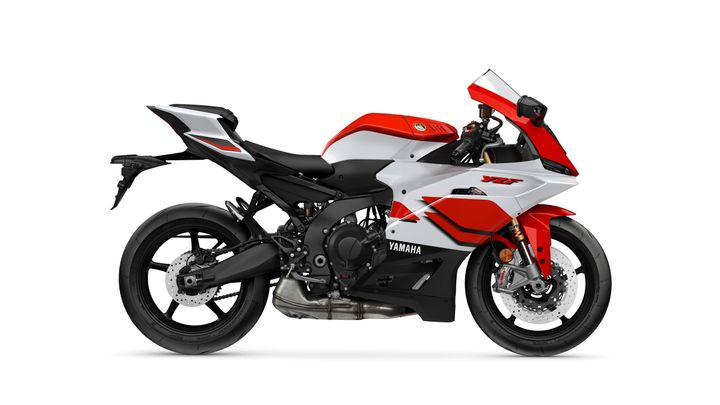 A red and white Yamaha motorcycle in a side view, showcasing its sleek design, aerodynamic fairing, and sporty features.