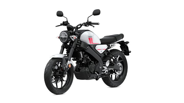 A modern gray and black motorcycle with a minimalist design, featuring a round headlight, sleek body lines, and a low seat, positioned at a dynamic angle.