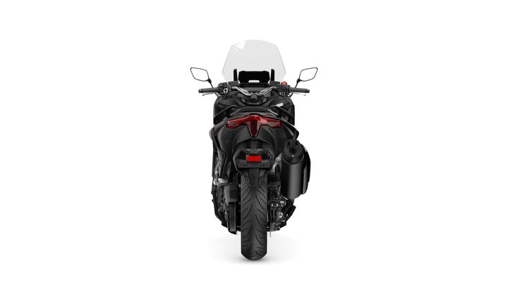 A rear view of a black motorcycle with a prominent rear tail light, exhaust pipe on the right, and a clear windshield at the front.
