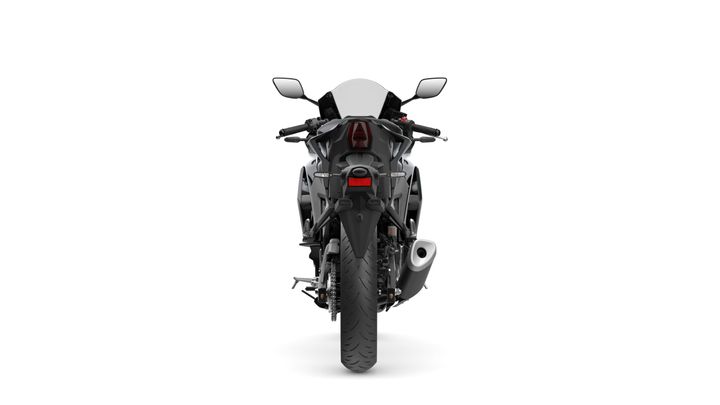 A sleek motorcycle viewed from the rear, showcasing its taillight, exhaust pipe, and aerodynamic design against a white background.