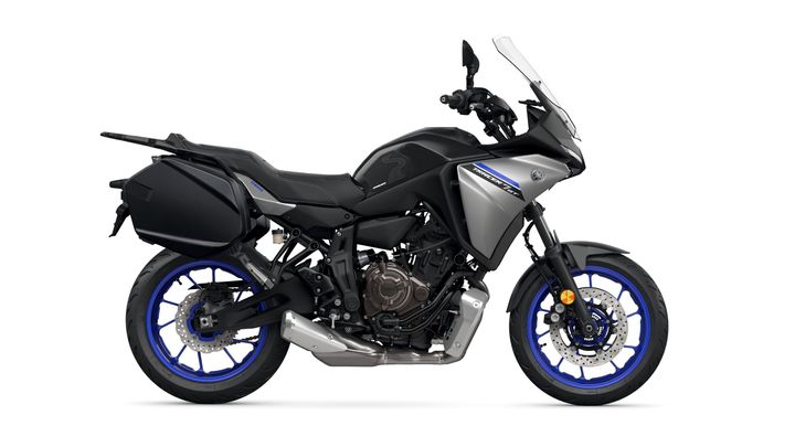 A sleek gray and black sport touring motorcycle with blue rims and a prominent windshield, featuring side panniers and an upright seating position.
