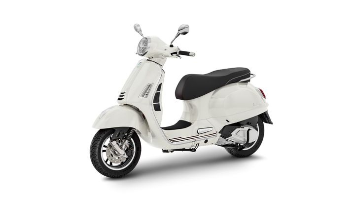 A sleek white scooter with a black seat, featuring a rounded body design, chrome accents, and a classic headlight, positioned at a slight angle on a white background.