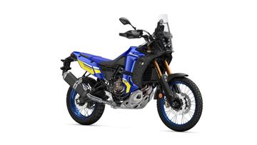 A blue and black adventure motorcycle with gold accents and a prominent windscreen, featuring off-road tires and a streamlined design, positioned on a white background.