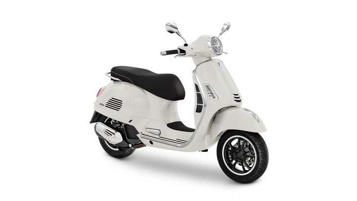 A white scooter with a black seat and stylish chrome accents, angled to showcase its rounded front and distinctive design.