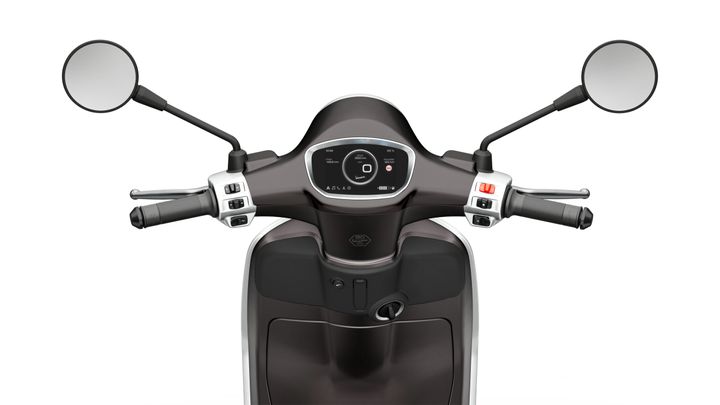 Front view of a scooter's handlebar, featuring two mirrors, a digital dashboard displaying speed and battery information, and control grips on either side.