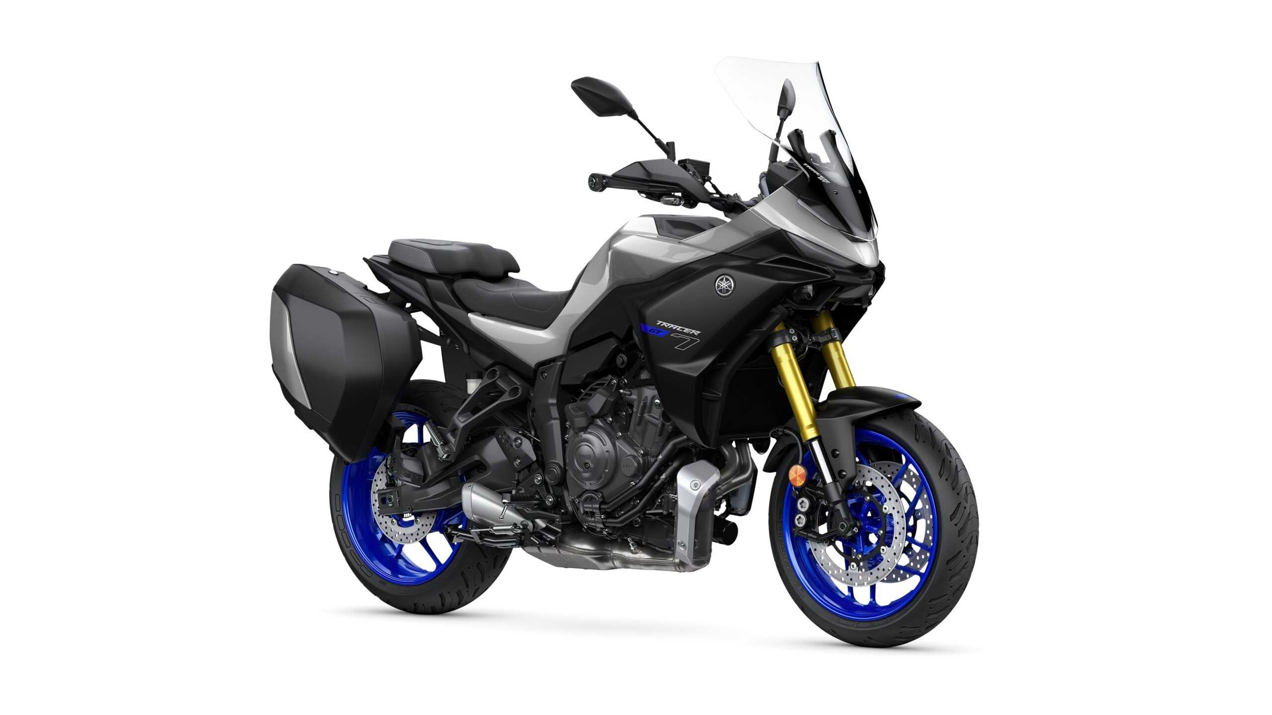 Yamaha 2026 Tracer 7 GT A sleek black and silver motorcycle with blue wheels, equipped with a windshield and side luggage, positioned on a white background.