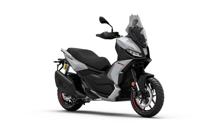 A sleek gray scooter with a black seat, sporty design, and off-road tires, positioned in a three-quarter view against a white background.