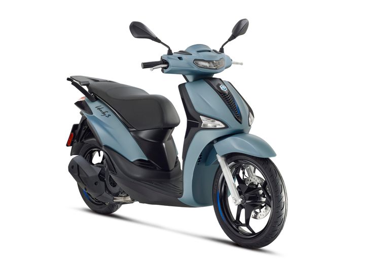 A sleek, modern scooter with a matte blue finish, featuring a comfortable black seat, stylish front headlamp, and alloy wheels.