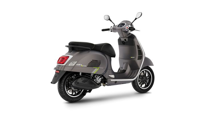 A sleek gray scooter with a comfortable black seat, featuring green accents, alloy wheels, and a modern design, shown from a rear angle.