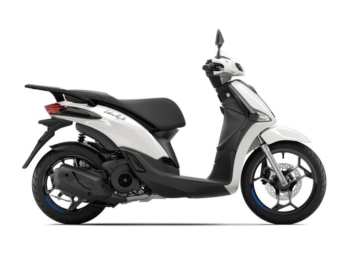 A sleek white scooter with a modern design, featuring a black seat and distinctive wheel styling. The vehicle is viewed from the side, showcasing its ergonomic shape and sporty appearance.