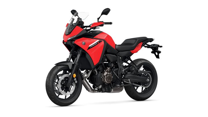 A red Yamaha Tracer 7 motorcycle is shown at a slight angle, showcasing its sporty design, dual front disc brakes, and modern features, set against a plain white background.