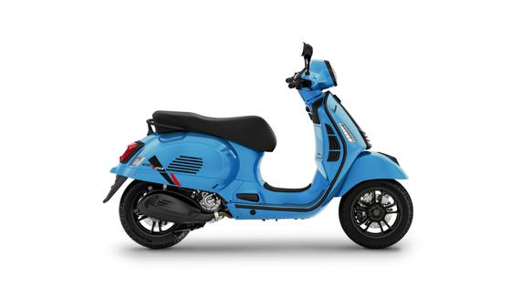 A side view of a bright blue scooter with a sleek design, featuring a comfortable black seat and stylish wheels.