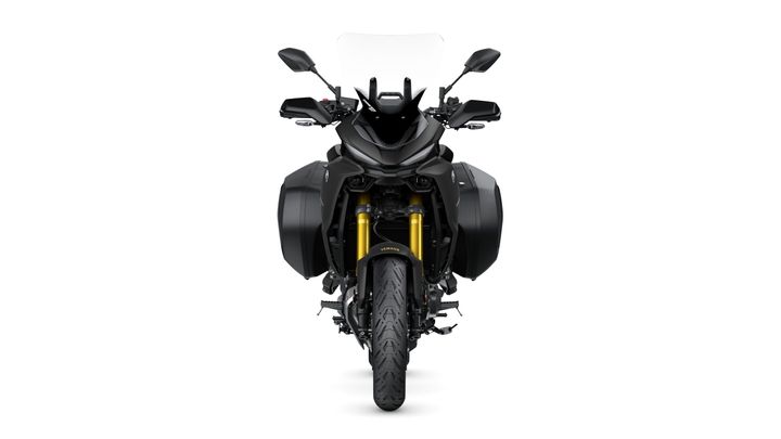 Front view of a black motorcycle with a transparent windshield, dual side bags, and prominent gold front forks, set against a white background.