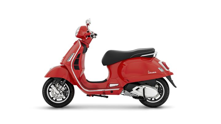 A vibrant red Vespa scooter viewed from the side, showcasing its classic design, smooth curves, and black seat.