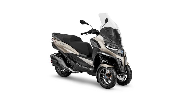 A modern three-wheeled motor scooter in a beige and black color scheme set against a white background.