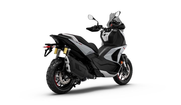 A modern black and gray motorcycle is positioned at an angle, showcasing its rear and side features, including dual rear shocks, distinctive exhaust, and sporty tires.