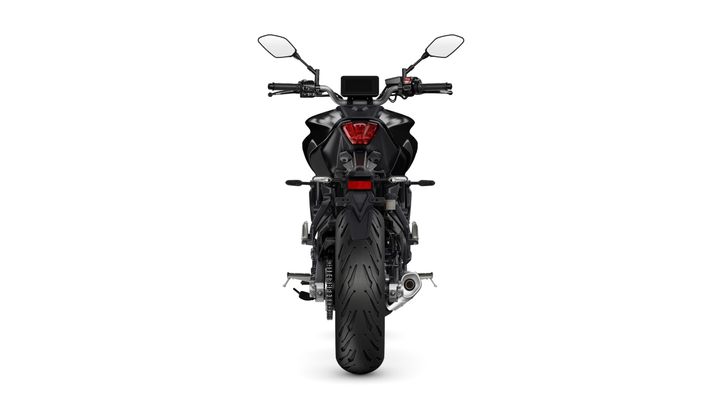 A rear view of a black motorcycle featuring a sleek design, prominent rear light, and a large rear tire. The handlebars and mirrors are visible, along with a digital instrument panel at the top.