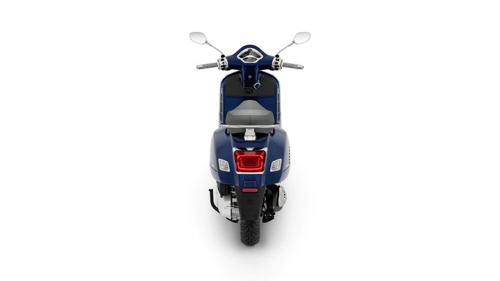 A blue scooter viewed from the rear, showcasing the tail light, seat, and handlebars.