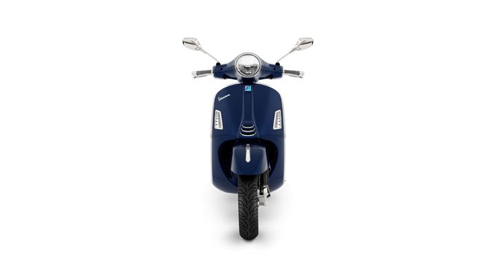 A sleek navy blue scooter is displayed head-on, showcasing its circular headlight, chrome mirrors, and distinctive front design.