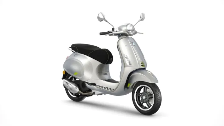 A silver-colored scooter with a classic design, featuring a round headlight, black seat, and alloy wheels, isolated on a white background.