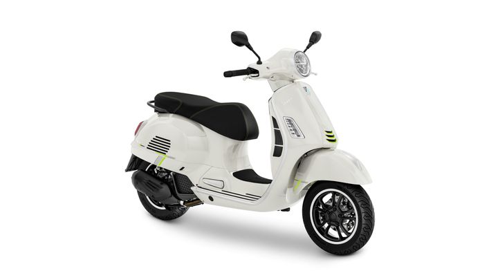 A sleek white scooter with black accents, featuring a rounded front, sporty wheels, and a comfortable seat.