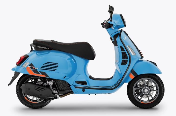 A blue motor scooter with black trim and seat, silver accents, and multi-spoke wheels, displayed in a profile view against a white background.