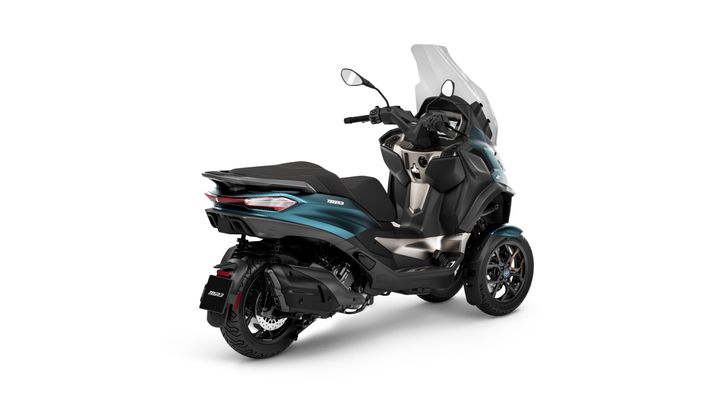 A modern three-wheeled motor scooter in black and turquoise with a tall windscreen and sleek bodywork, positioned at a three-quarter angle on a white background.