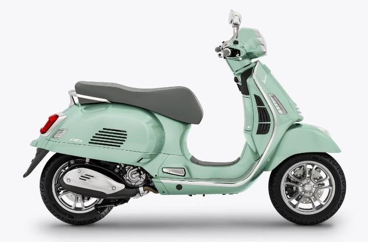 A mint green Vespa scooter on a white background.