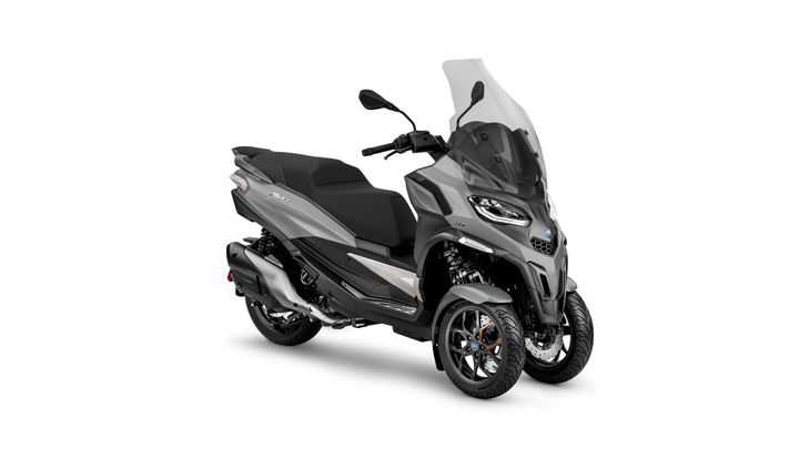 A sleek gray three-wheeled scooter with a large windscreen, sporty design, and black seating.
