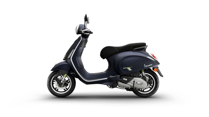 A sleek, dark blue scooter with a curved design, featuring a black seat and vibrant green accents, viewed from the side against a white background.
