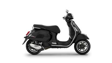 A sleek black scooter positioned sideways, showcasing its modern design, chrome accents, and detailed wheel features against a white background.